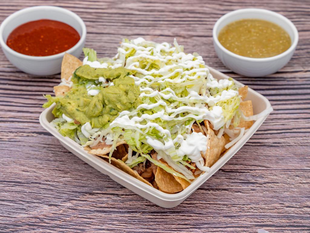 Nachos · Choice of meat, beans, cheese, lettuce, guacamole, sour cream, onions and cilantro.