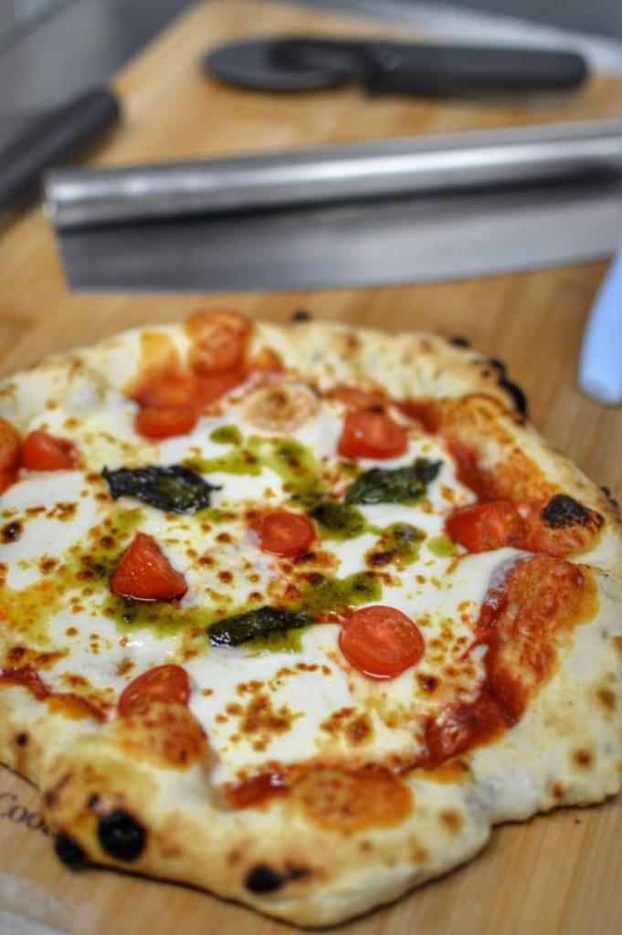Caprese Pizza · Tomato sauce, fresh mozzarella, tomato cherry slices, basil, pesto oil.