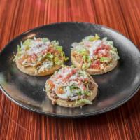 Sopes · 3 sopes shredded chicken, ground beef and cochinita pibil each smothered with Refried beans ...
