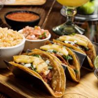 Tacos al Pastor · 3 soft corn tacos with strips of pork marinated in our special chile ancho sauce, topped wit...