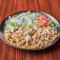Arroz con Pollo · Grilled chicken over rice topped with cheese sauce, served with tomatoes, lettuce, sour crea...