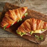 Croissant Sandwich · Mozzarella, cheddar, Parmesan, bacon bits, ham turkey, arugula, tomato, mashed avocado on th...