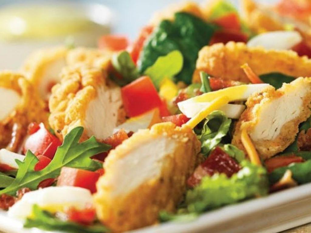 Crispy Chicken Tender Salad · Chicken tenders, hard-boiled eggs, hardwood-smoked bacon crumbles, tomatoes, croutons and Cheddar on mixed greens. Served with choice of dressing.