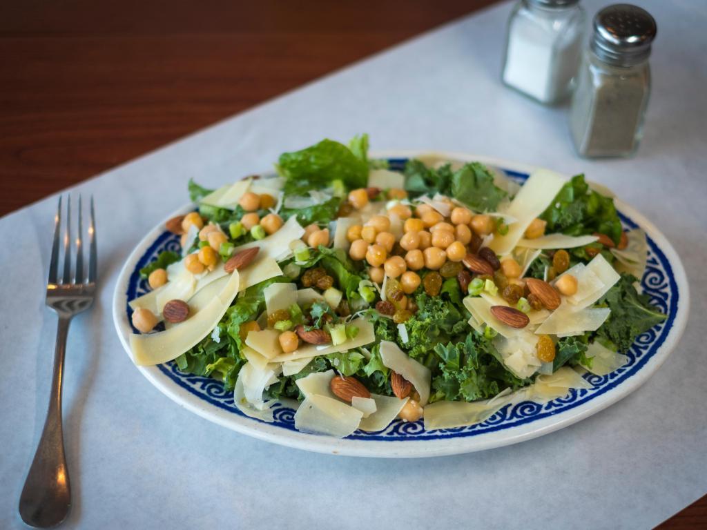63. Kale Salad · Kale and romaine with golden raisins, toasted almonds, scallions and garbanzo beans with grated Parmesan cheese with lemon vinaigrette dressing.