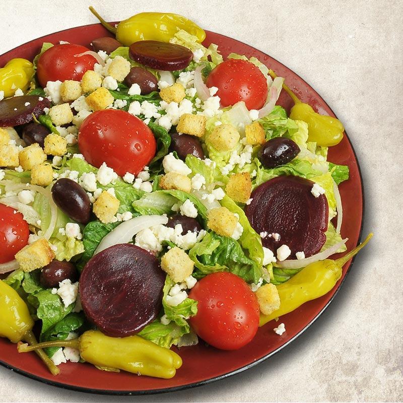 Greek Salad · Romaine lettuce, tomatoes, feta cheese, beets, Kalamata olives, onions, cucumbers, pepperoncini, and Greek dressing.