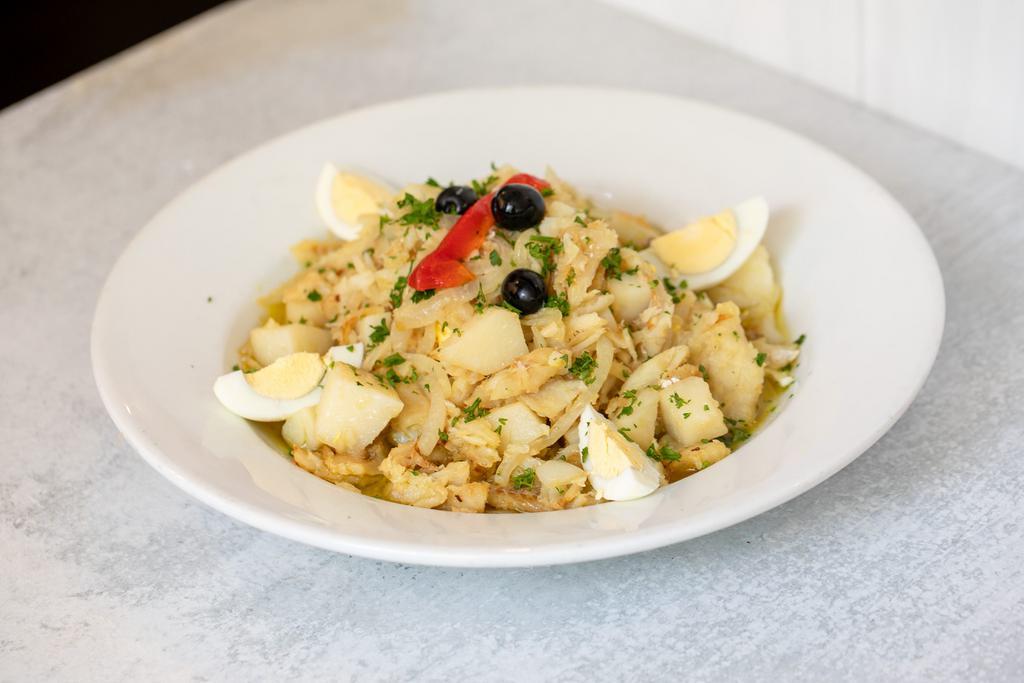 Bacalhau à Gomes Sà · Shredded codfish mixed with steamed Potatoes, boiled Eggs, Garlic, Onions and topped with Olive Oil