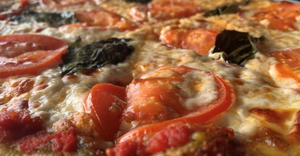 Tomato Basil Pizza  · Medium-thin crust with red wine marinara.  Garlic/Pesto/Basil brushed crust, covered with mozzarella cheese, Locally sourced Tomato slices and fresh Basil leaves. 