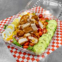 Crispy or Grilled Chicken Salad · A bed of mixed green lettuce topped with tomatoes, red onions, cucumbers, eggs, shredded che...