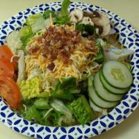 House Salad · Iceberg/Romaine blend, fresh mushrooms, tomato, cucumber,  real bacon bits, & cheddar jack c...