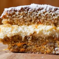 Slice of Carrot & Walnut Cake with Cream Cheese Frosting · Our carrot cake is fuffy, dense and light. Made with grated carrot, walnuts and a layer of r...