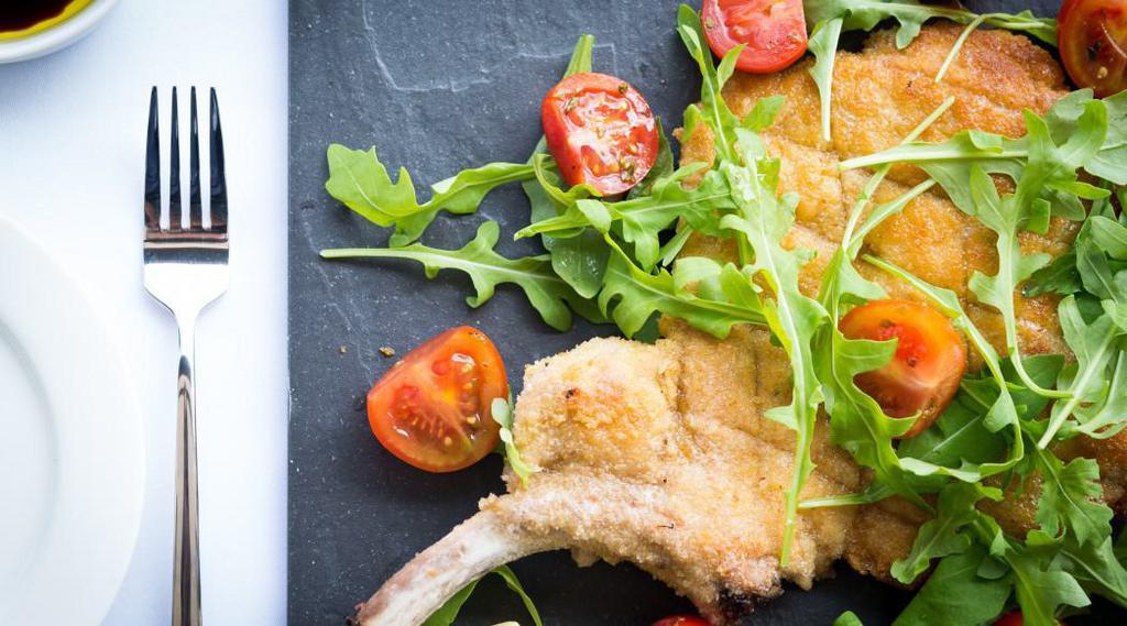 Costoletta di Vitello alla Milanese · 
Pan Fried Pounded and Breaded  Veal Chop Milanese Served w/ Arugula, Cherry Tomato Salad and Lemon Dressing 
