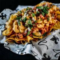 Nacho-ronies (D) · Fresh fried chips, topped with cajun pulled chicken, nacho cheese macaroni, fresh cut pico d...