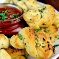 4 Garlic Knots · Classic Italian pizzeria snack, garlic knots are strips of pizza dough tied in a knot, baked...