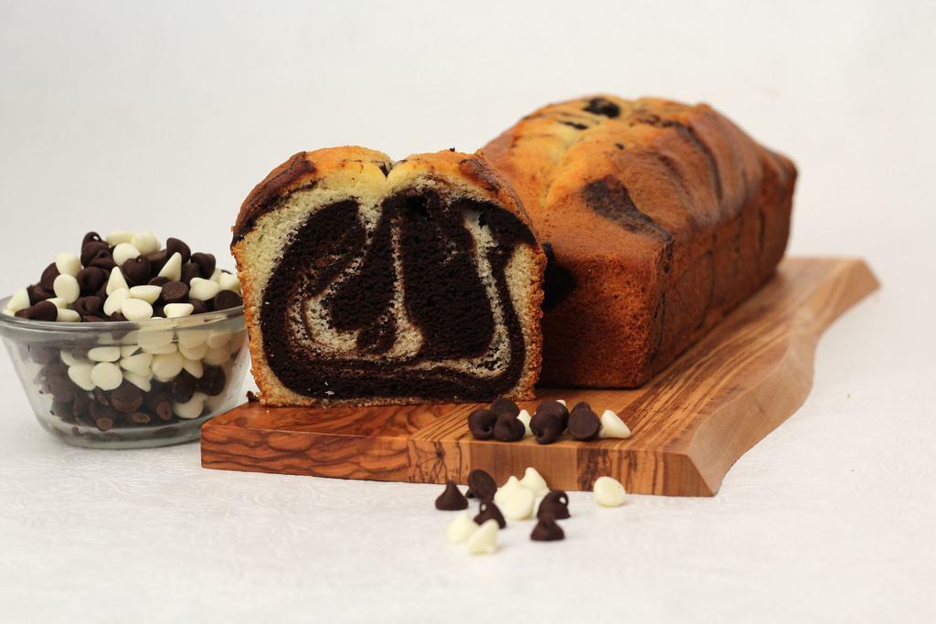 Marble Bread · Deep chocolate leads and the equally talented moist vanilla compliments dancing backward. Delicately hand swirled. Full large loaf ready to slice as you wish. Made in a facility that uses dairy, eggs, nuts, and wheat products.