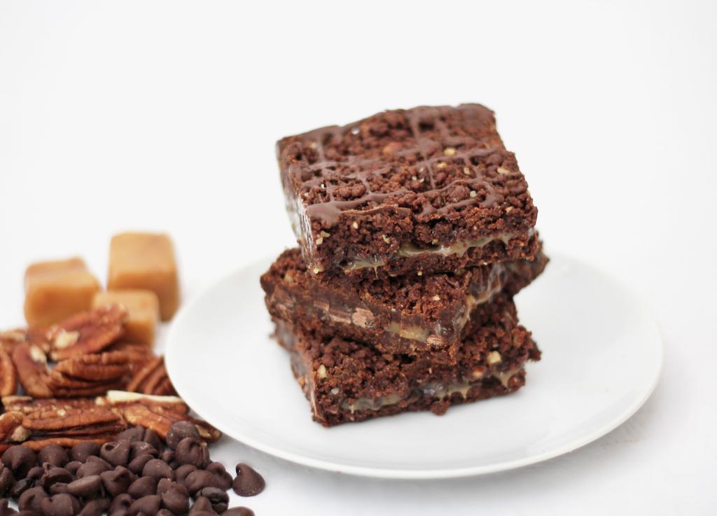 Praline Fudge Bar · Chunky chocolate, soft toffee and dark chocolate in a pecan brownie. Box of 12 bars. Baked in a facility that uses dairy, nuts, and wheat products.
