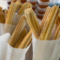 Traditional Churros  · 4 traditional churros sprinkled with sugar and cinnamon.