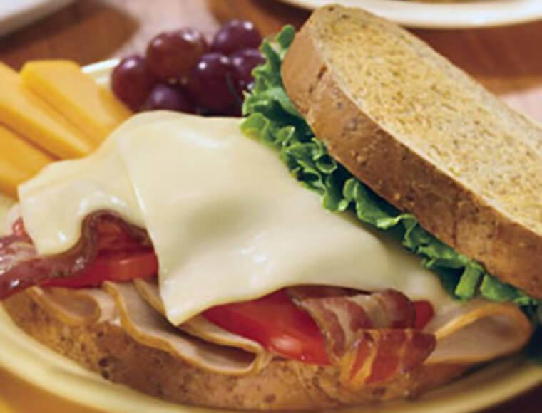 Delicious Turkey Bacon Melt Sandwich · Melted cheddar lends a new flavor to this hot turkey sandwich with crisp bacon and melted American cheese. (Roasted turkey, bacon, melted cheddar, lettuce, tomato and mayonnaise.)