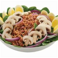 Spinach Salad · Tender baby spinach greens topped with crumbled bacon, red onion, fresh mushrooms and hard-b...