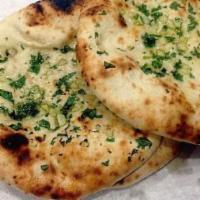 Garlic Naan · Light leavened bread topped with garlic and butter baked in the clay oven.