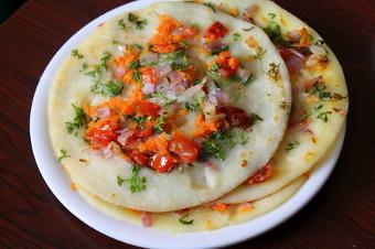 Utappam · Indian pizza (dosa style) topped with onions, chilies, and grated carrot.