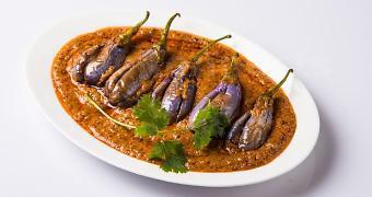 Baghara Baingan · Stuffed eggplant cooked in spiced onion and tomato gravy.