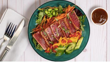 Seared Ahi tuna Salad · Mixed greens with arugula, seared ahi tuna, shallots, cucumber, edamame, carrots, bell peppers, sesame vinaigrette.