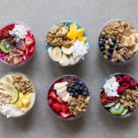 Coconut Colada Bowl · Pineapple, strawberry, banana, granola, coconuts flakes, and agave.