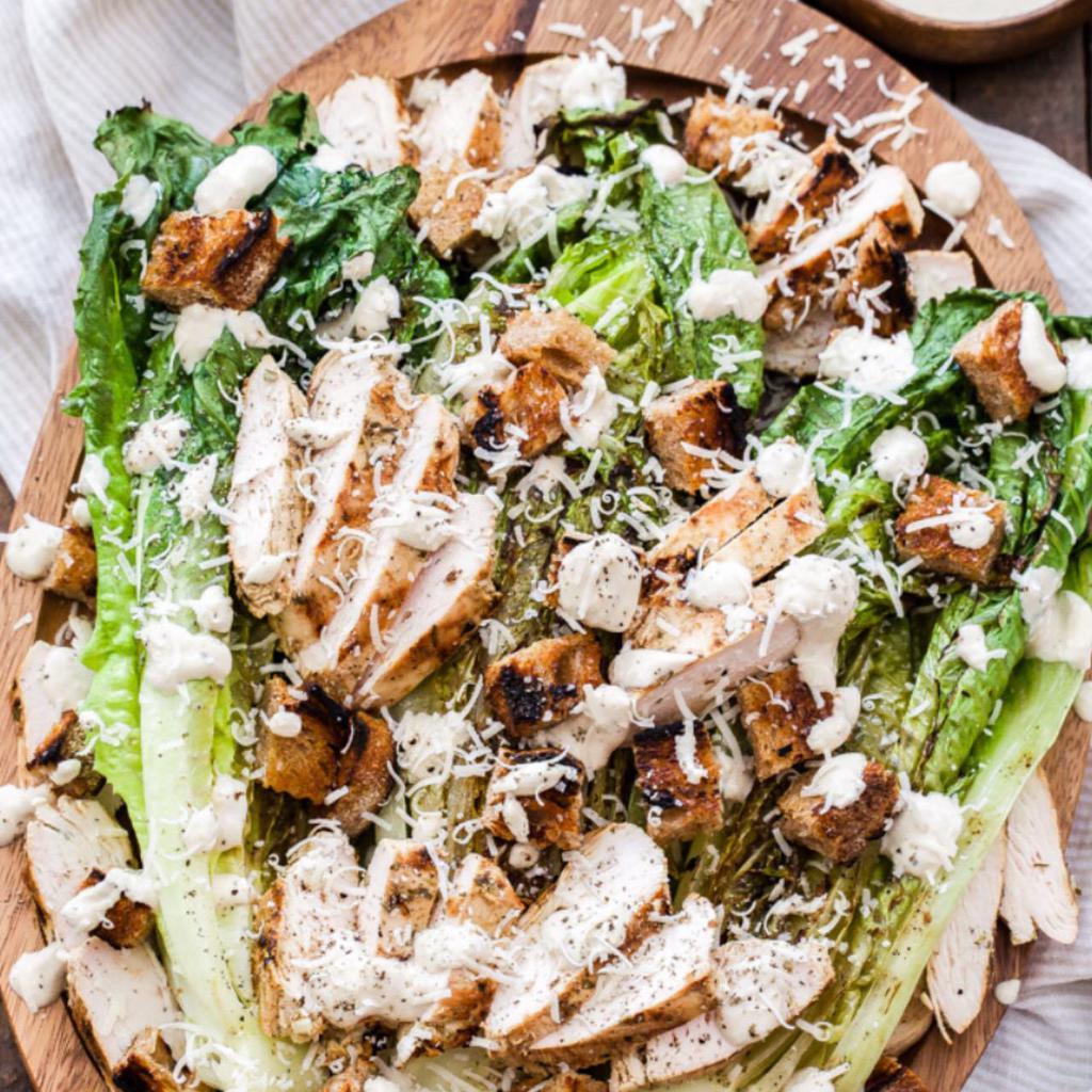 Grilled Chicken Caesar Salad · Marinated ＆ Grilled Chicken served on top of fresh cut Romaine lettuce w/ parmesan and garlic croutons ＆ creamy caesar dressing.