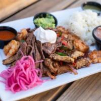 Fajitas · Grilled steak, chicken, or shrimp with sautéed peppers and onions, served with sour cream, g...