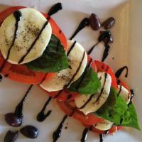 Mozzarella Caprese · Sliced organic tomatoes, basil, imported fresh mozzarella and olives, served with olive oil ...