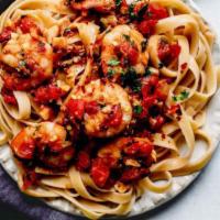 Fettuccine alla Fra' Diavola · Jumbo shrimp sauteed with a spicy tomato sauce, garlic, and chopped tomatoes, served on a be...
