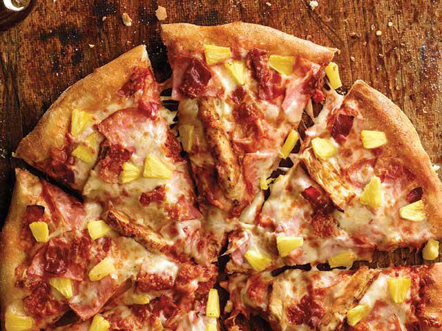 Hawaiian Chicken Pizza · Ham, grilled chicken, bacon, pineapple, sauce and three cheese blend.