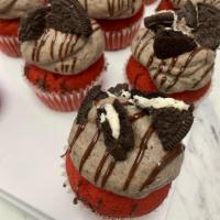 Red Velvet Cookies & Cream · Red Velvet Cupcake with a Cookies & Cream Cream Cheese frosting drizzle with fudge and toppe...