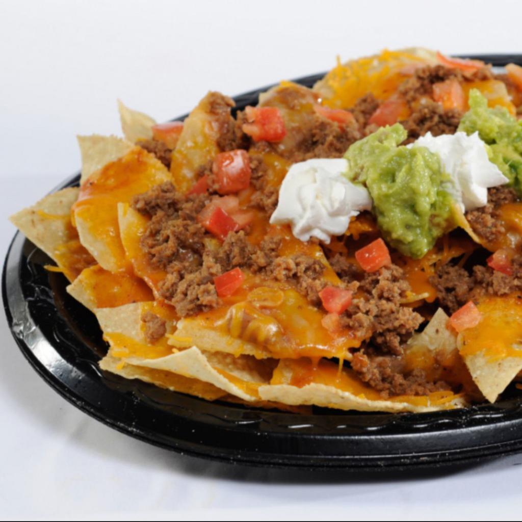 Meat Nacho · Crisp corn chips covered with refritos, enchilada sauce, melted cheddar and jack cheese and topped with seasoned ground beef, guacamole, sour cream and tomatoes.