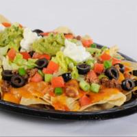 Meat Works Nacho · An appetizer or a meal in itself! Crisp corn chips covered with refritos, enchilada sauce, m...
