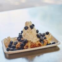 Creme au Citron · Lemon curd topped with whipped cream garnished with blueberries.