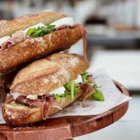 Prosciutto Sandwich · Savory prosciutto di parma, fresh mozzarella, fresh arugula and our signature pesto spread i...