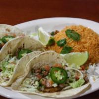 Tacos de Pescado · 3 flour tortillas with grilled tilapia with pico de gallo and lettuce. Served with rice on t...