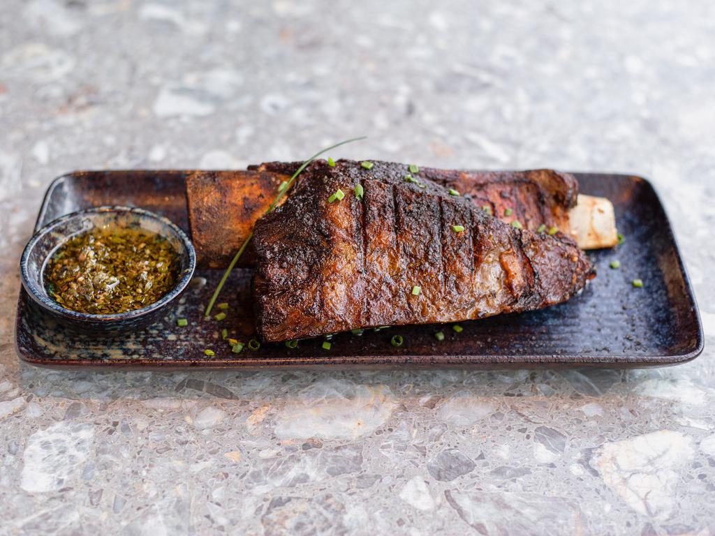 Asado de Tira · Slow-grilled short ribs. All beef is imported from Argentina, highest quality grass-fed black Angus, hand-cut and grilled gaucho-style on our Argentinian parrilla. Served with choice of homemade chimichurri or oyster-malbec sauce .