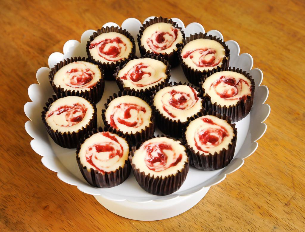 Strawberry Swirl Cheesecake Minis - 1 Dozen · Freshly made sweet strawberry compote layered throughout our classic cheesecake. Baked on our from scratch graham cracker crust.  