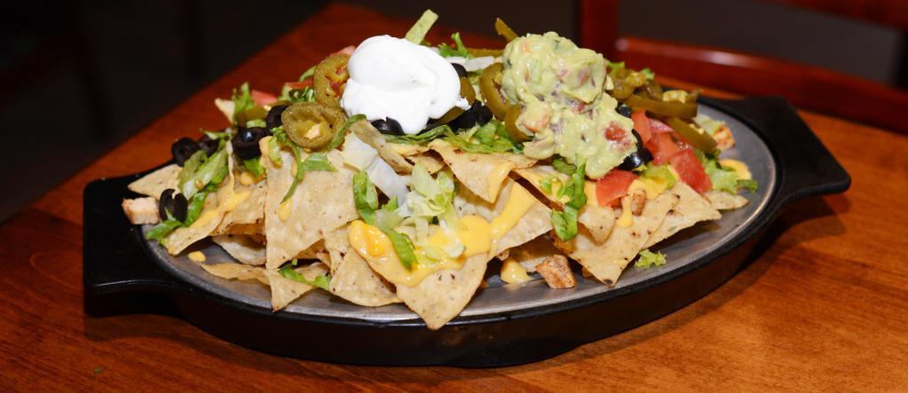 Supreme Nachos · Homemade tortilla chips, jalapeno, black olives, tomato, cheese, sour cream. Add meat and guacamole for an additional charge.
