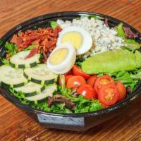 The Classic Cobb Salad · Lettuce, tomatoes, hard-boiled eggs, cucumbers, bacon, avocado, blue cheese crumble, and you...