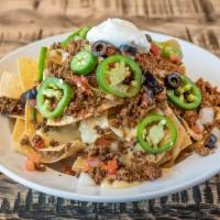 Nachos · Corn tortilla chips smothered in queso and topped with beef or chicken, pico de gallo, fresh...