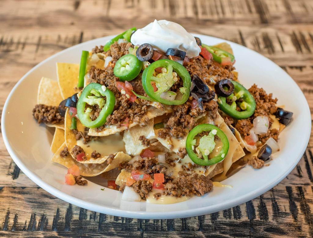 Nachos · Corn tortilla chips smothered in queso and topped with beef or chicken, pico de gallo, fresh jalapenos, black olives and sour cream. Served with a side of salsa. Gluten free.