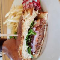 Vegan Burger · Beyond burger patty, grilled tofu, lettuce, onions, tomatoes and our secret sauce on a brioc...