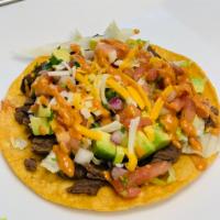 tostada · Toasted Corn Tortilla topped with Lettuce, Pico, Cheese, Fried Black Beans and your choice o...