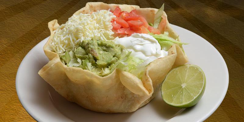 Taco Salad · Crisp flour tortilla shell with choice of ground beef or chicken, lettuce, beans, tomatoes, cheese, sour cream and guacamole.