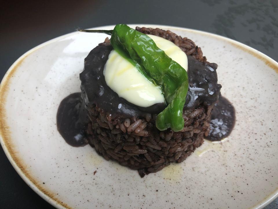 Rice & Beans · Our play on Dirty Rice. Rice cooked in a puree of seasoned black beans with a dab of garlic aioli and a blistered shisito pepper