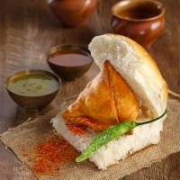 Samosa Pav · Potatoes, peas and spices filled in a triangular pastry served with 
buttered bun, tamarind ...