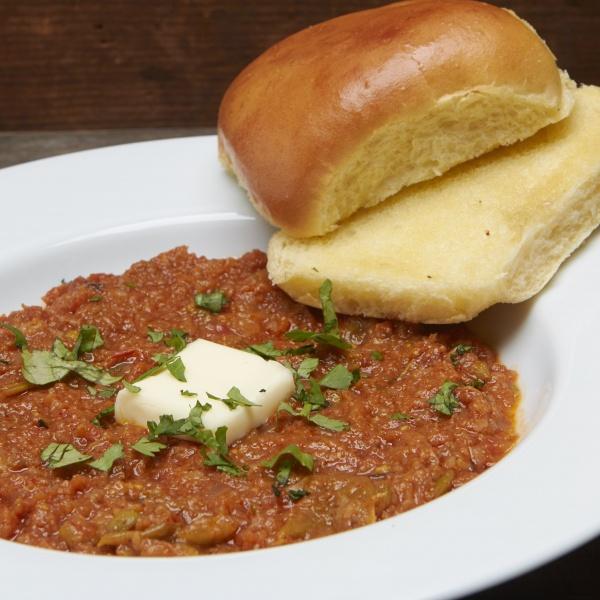 Pav Bhaji · Thick potatoes, tomatoes, cauliflower, peas, green peppers, onion and garlic curry, topped onions and cilantro, served with buttered bread. 